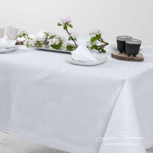 White linen tablecloth with flower ornaments, folded border