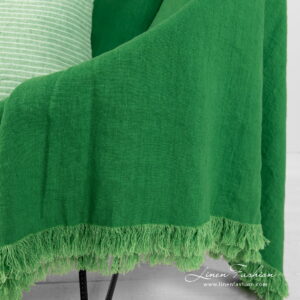 linen green throw with loose fringes.