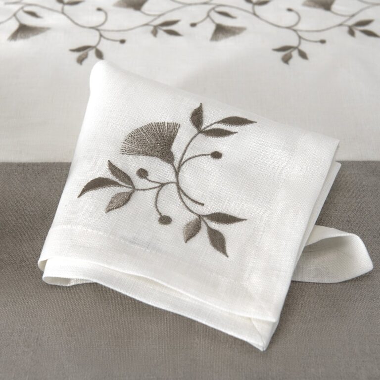 Off-white napkin with brownish floral stitching