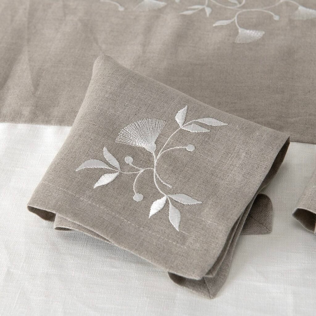 Natural linen napkin with white floral stitching