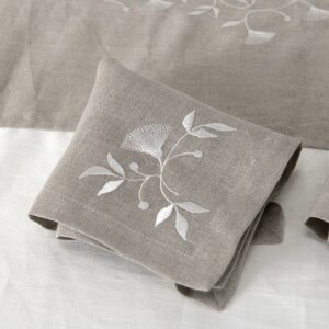 Natural linen napkin with white floral stitching
