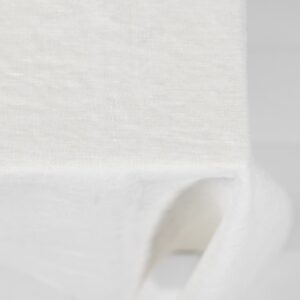 white linen tablecloth with decorative seam. off white background.