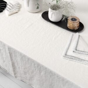 white linen tablecloth with decorative seam with napkins.