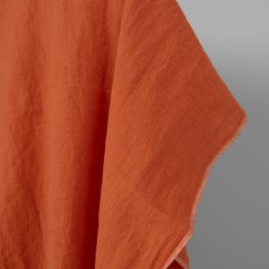 Washed linen fabric in dark orange, fabric edge