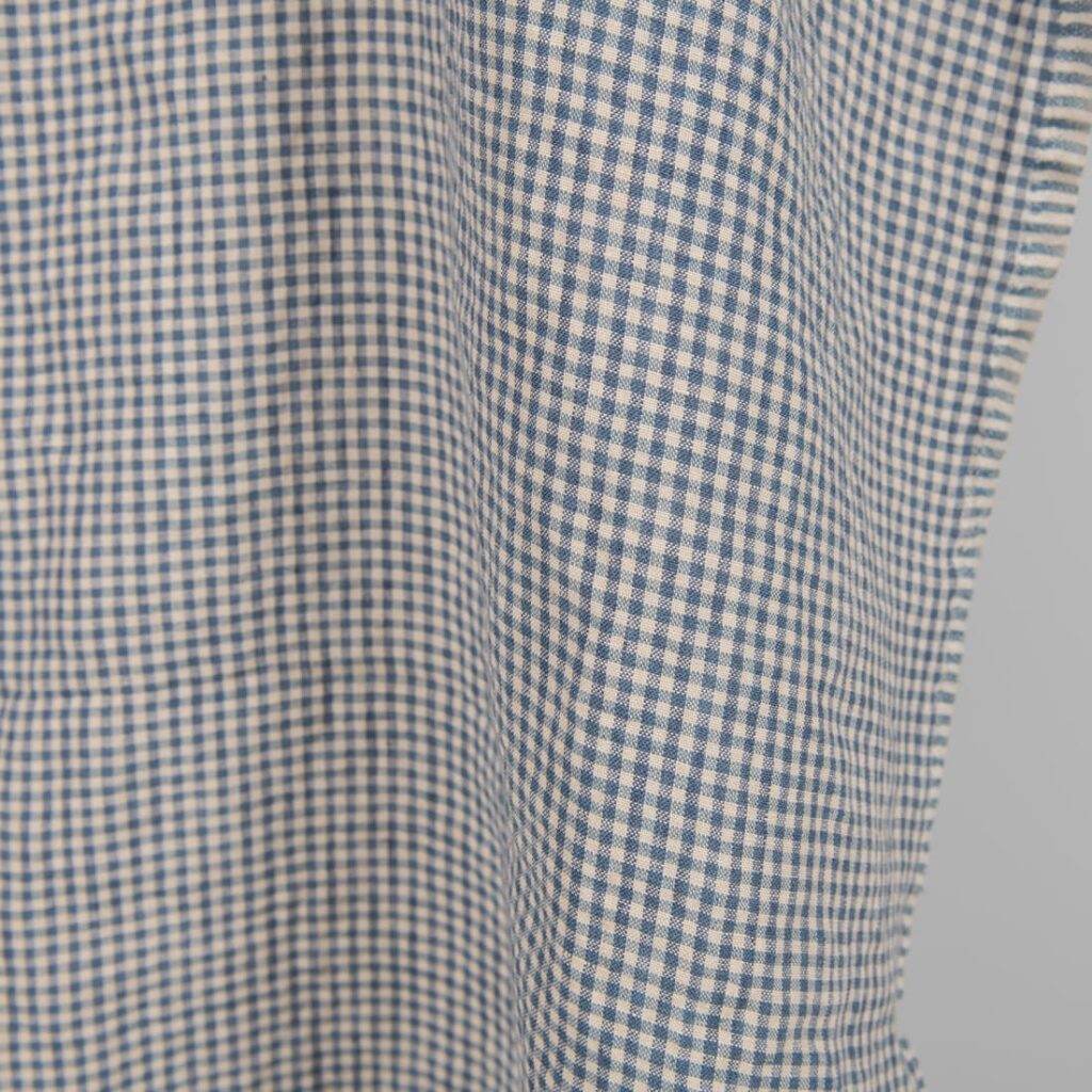 Vasket linstoff med små blå og brunaktige ruter 4 Washed linen fabric with small blue and brownish checks close edge view