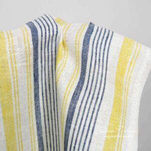 Smalt hvitt linstoff med blå og gule striper