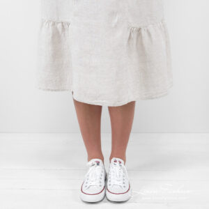 beige long linen dress with ruffles at bottom.