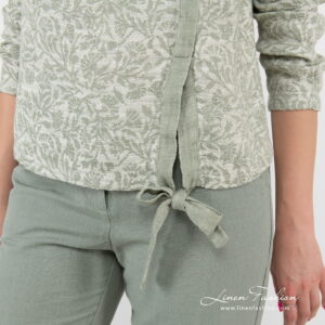 green flower blouse with knotted ribbom at bottom.